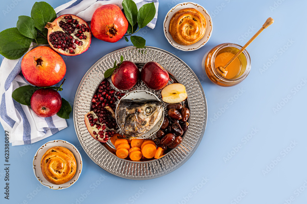 A silver dish with traditional food Rosh Hashanah. pomegranates, apples