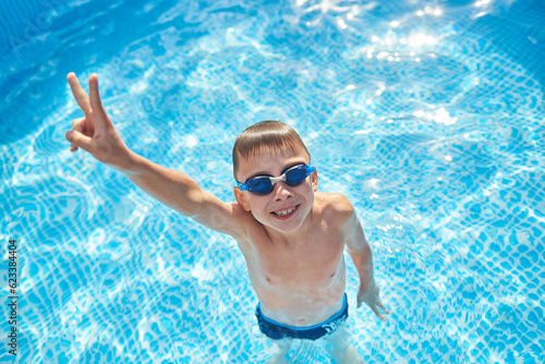 8 year old boy having fun in the home swimming pool