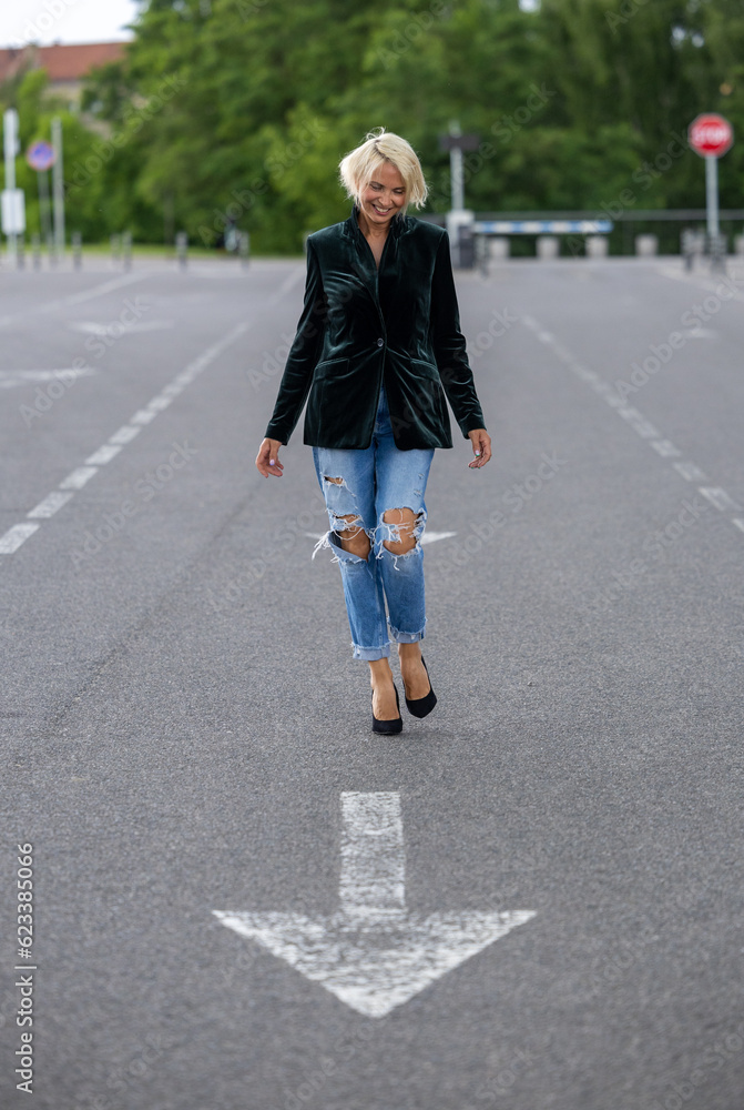 Blonde adult woman posing with a good mood on a road sign Blonde adult woman posing with a good mood on a road sign