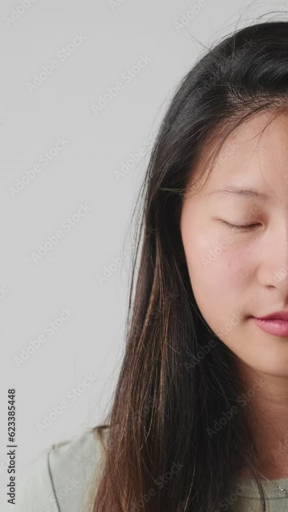Close up, half face young woman opens her eyes looking at camera and smiling isolated over white background in studio Close up, half face young woman opens her eyes looking at camera and smiling isolated over white background in studio