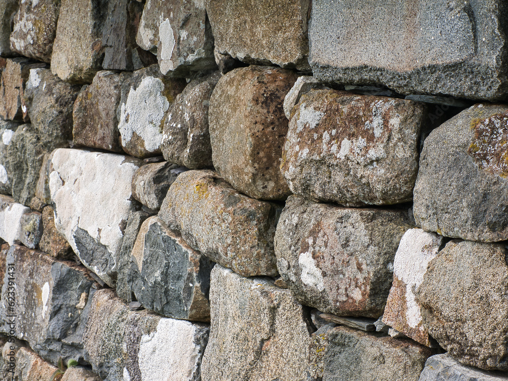 old house wall made of stone. Stones in different sizes and colours