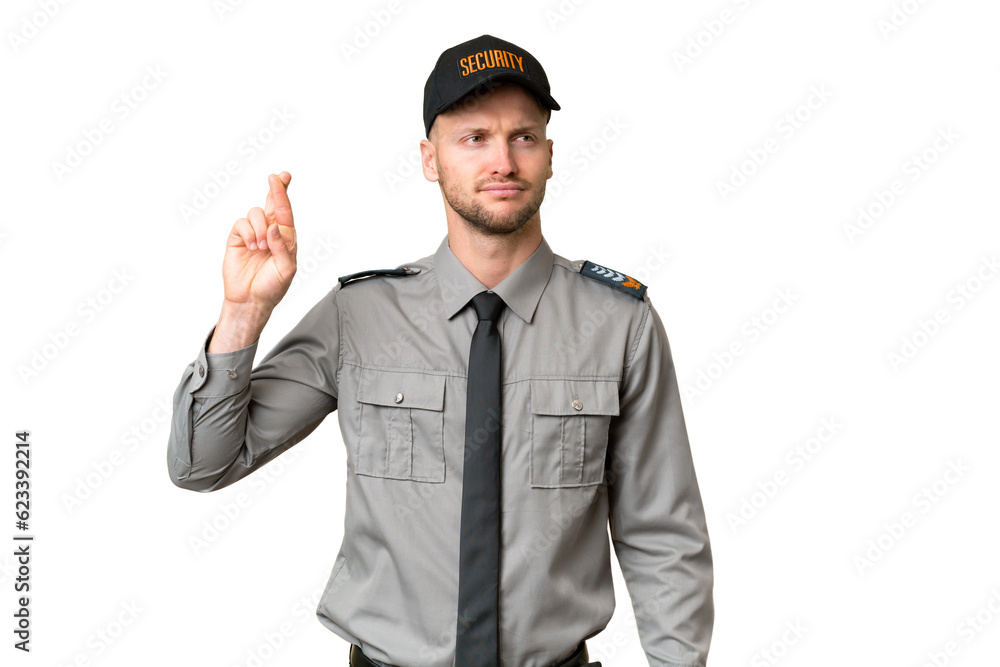 Young security caucasian man over isolated background with fingers crossing and wishing the best Young security caucasian man over isolated background with fingers crossing and wishing the best