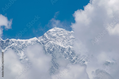 Amazing view of Mt. everest 8848 m high. Highest mountain on earth seen from tangboche. Clouds covered snow peaks and clear blue skies. glaciers and icy himalayan peaks seen during ebc trek in nepal.