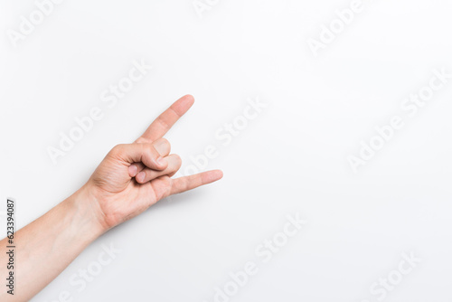 A man's hand in close-up shows a rock or punk gesture on a white background.