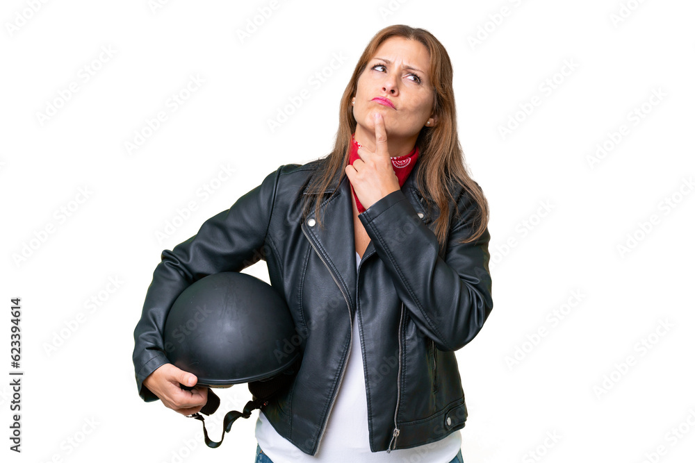 Middle-aged caucasian woman with a motorcycle helmet over isolated background having doubts while looking up Middle-aged caucasian woman with a motorcycle helmet over isolated background having doubts while looking up