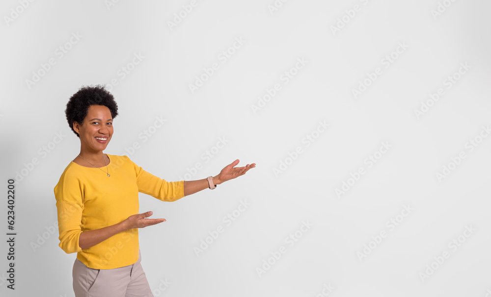 Smiling female promoter presenting new product on copy space while standing over white background