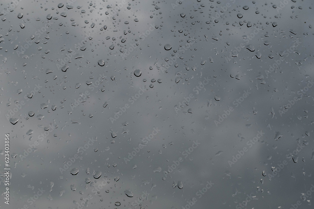 Blurred image of raindrops on glass against a gray sky. Blurred image of raindrops on glass against a gray sky.