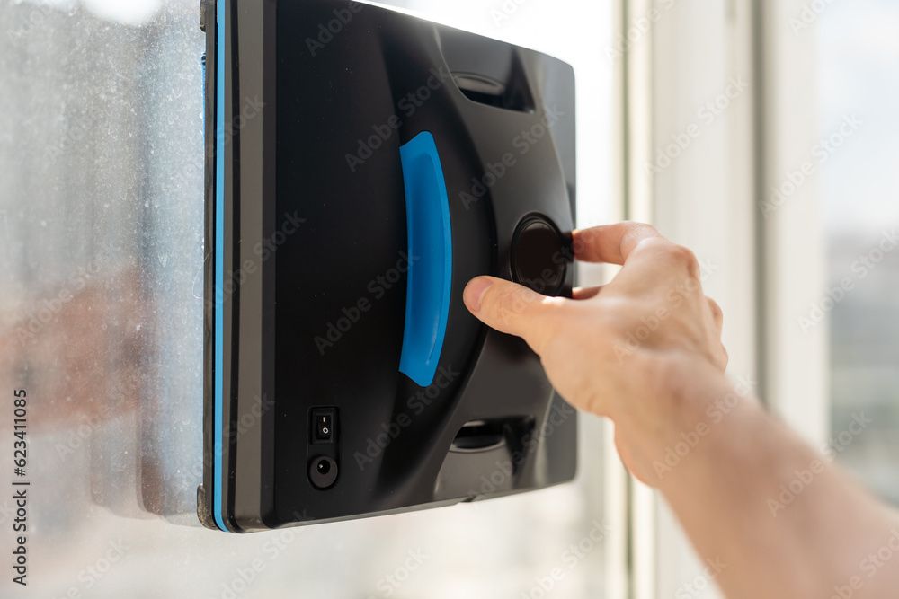 The white robotic window cleaner uses a brush and vacuum for a thorough