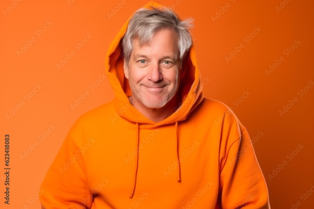 Medium shot portrait photography of a satisfied mature man wearing a comfortable hoodie against a bright orange background. With generative AI technology Medium shot portrait photography of a satisfied mature man wearing a comfortable hoodie against a bright orange background. With generative AI technology