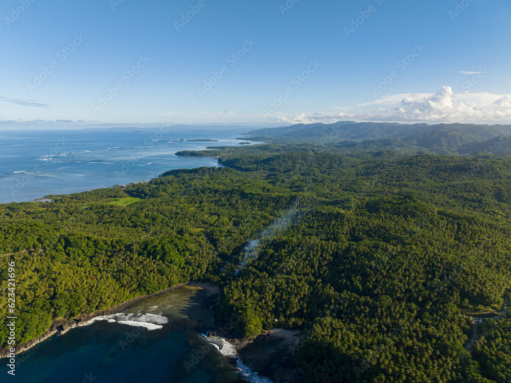 Top view of Tropical Landscape. Blue sky and ocean waves. Surigao del Sur. Mindanao, Philippines. Top view of Tropical Landscape. Blue sky and ocean waves. Surigao del Sur. Mindanao, Philippines.