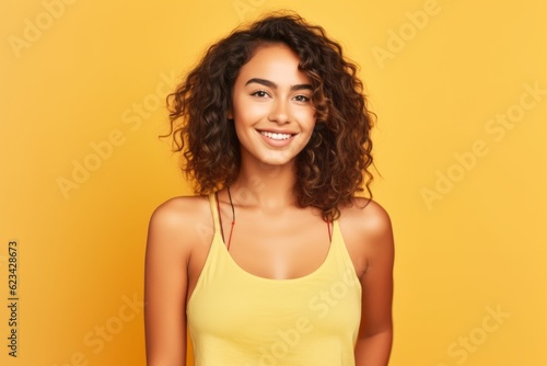 Medium shot portrait photography of a beautiful girl in her 20s wearing a stylish tank top against a pastel yellow background. With generative AI technology