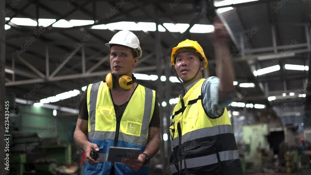 group of two diversity caucasian industrial Engineer manager man discussion with asian mechanic worker man using tablet checking machinery in industry manufacturing large factory. talking on site group of two diversity caucasian industrial Engineer manager man discussion with asian mechanic worker man using tablet checking machinery in industry manufacturing large factory. talking on site