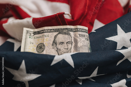 business and economic concept, Untied States five dollar bill on an american flag with a blank check photo