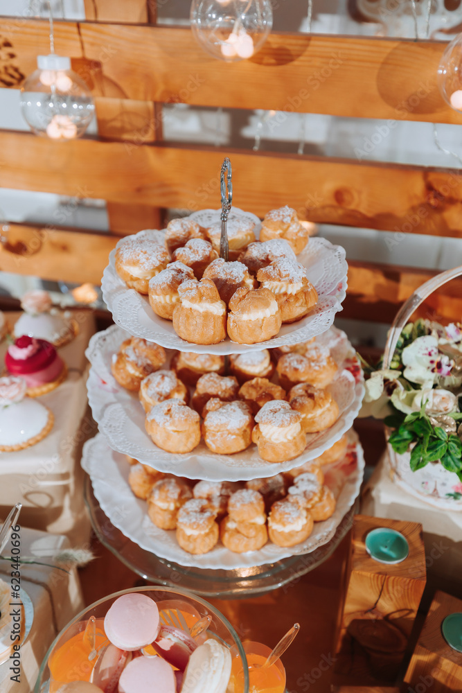 Festive dessert table with sweets. Wedding candy bar, various cakes, chocolates on stands.