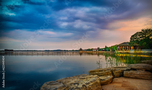 The ancient Chinese architecture by the lakeside under the setting sun