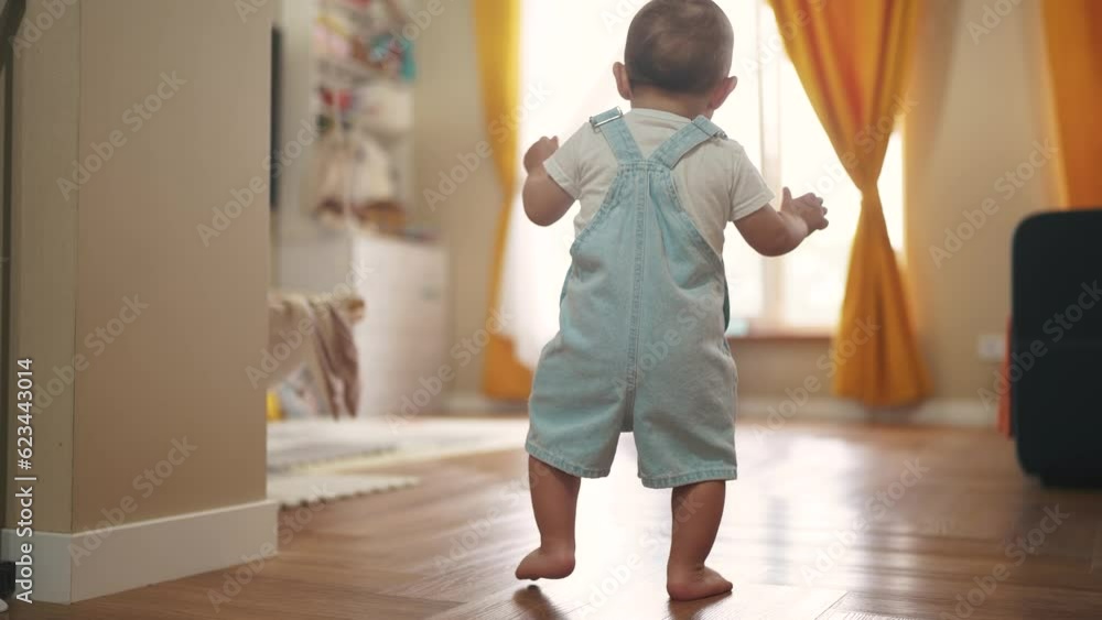 baby first steps. baby goes to her father at window learns to walk to take first steps. happy family kid dream concept. dad calls son baby first steps indoors. happy family indoors concept lifestyle