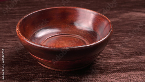 Empty wooden bowl and wooden spoon isolated with copy space.