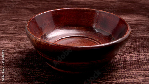 Empty wooden bowl and wooden spoon isolated with copy space.
