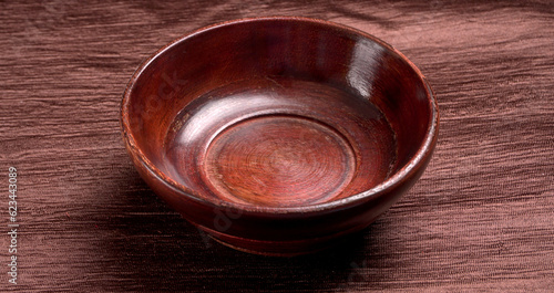 Empty wooden bowl and wooden spoon isolated with copy space.