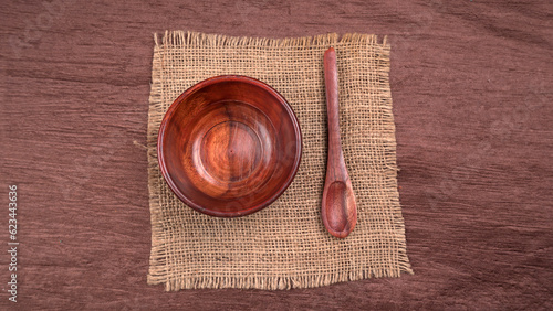 Empty wooden bowl and wooden spoon isolated with copy space.