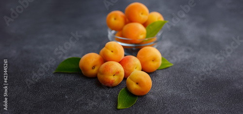 Delicious ripe Fresh juicy apricots on black background, close-up. Selection of healthy vegetarian food, detox or diet concept. © YURII Seleznov
