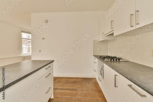 a kitchen with white cupboards and black counter tops on the counters in this photo is taken from the inside