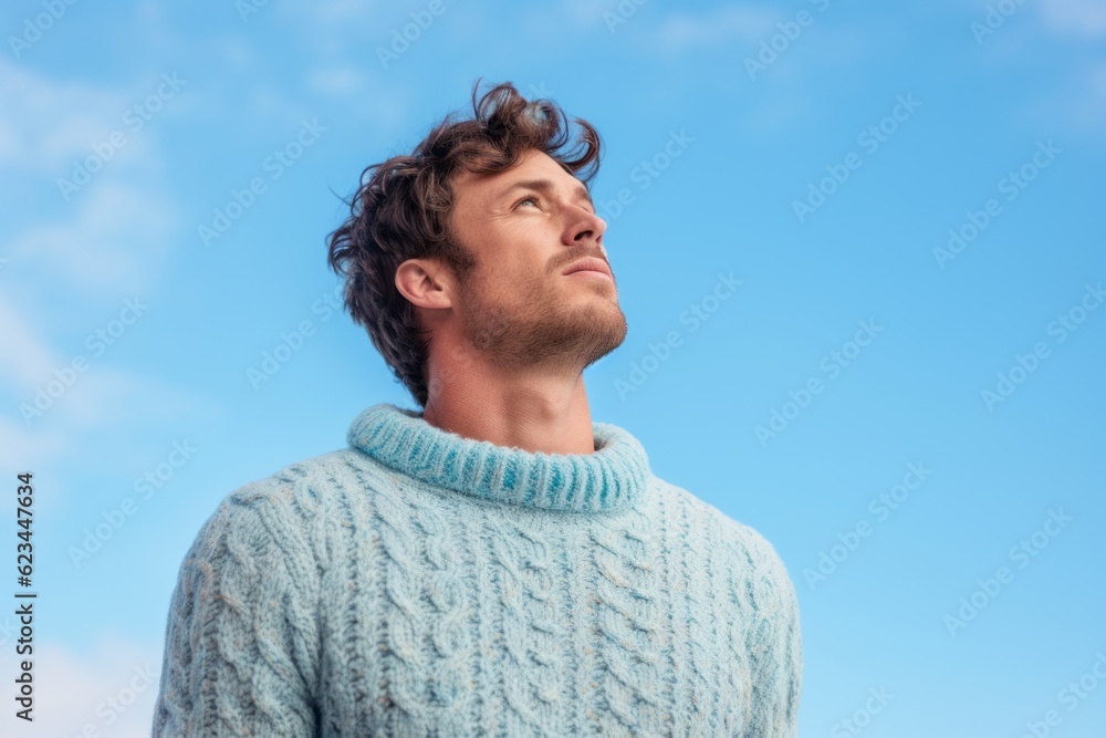 Conceptual portrait photography of a beautiful boy in his 30s wearing a cozy sweater against a sky-blue background. With generative AI technology Conceptual portrait photography of a beautiful boy in his 30s wearing a cozy sweater against a sky-blue background. With generative AI technology