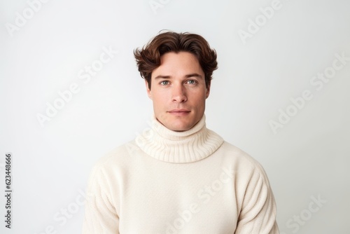 Environmental portrait photography of a glad boy in his 30s wearing a classic turtleneck sweater against a pearl white background. With generative AI technology © Markus Schröder