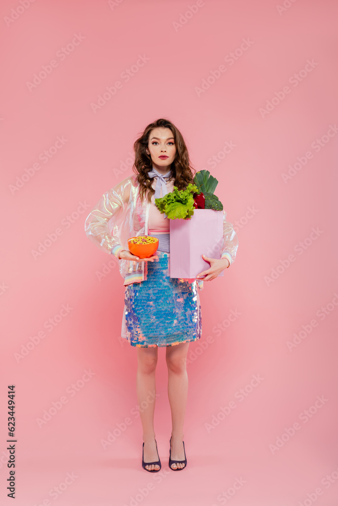 housewife concept, doll like, attractive young woman carrying grocery bag with vegetables, model with wavy hair on pink background, conceptual photography, home duties, stylish wife housewife concept, doll like, attractive young woman carrying grocery bag with vegetables, model with wavy hair on pink background, conceptual photography, home duties, stylish wife