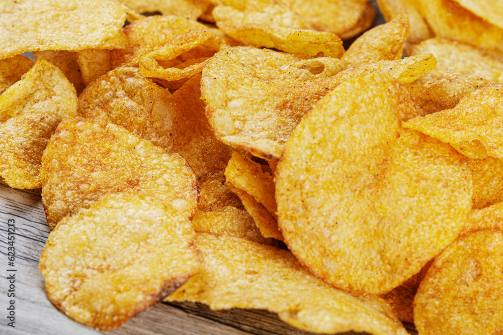 Delicious Barbeque Flavored Potato Chips isolated on a wooden background Delicious Barbeque Flavored Potato Chips isolated on a wooden background
