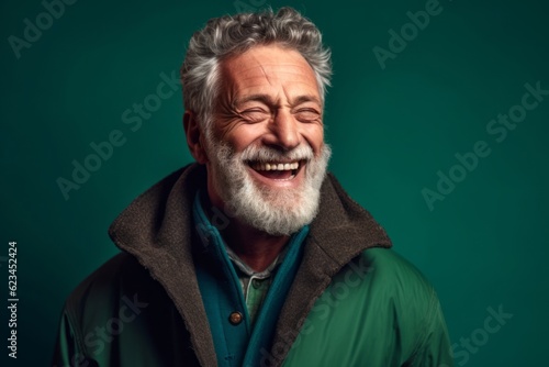 Headshot portrait photography of a joyful mature man wearing a cozy winter coat against a spearmint green background. With generative AI technology