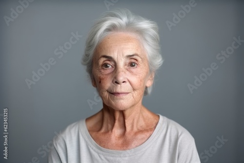 Medium shot portrait photography of a tender old woman wearing a casual t-shirt against a minimalist or empty room background. With generative AI technology