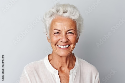 Close-up portrait photography of a happy old woman wearing a classy button-up shirt against a minimalist or empty room background. With generative AI technology