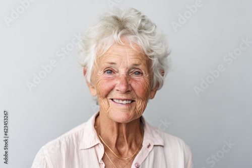 Close-up portrait photography of a happy old woman wearing a classy button-up shirt against a minimalist or empty room background. With generative AI technology