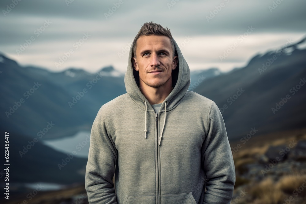 Sports portrait photography of a glad boy in his 30s wearing a stylish hoodie against a mountain range background. With generative AI technology Sports portrait photography of a glad boy in his 30s wearing a stylish hoodie against a mountain range background. With generative AI technology