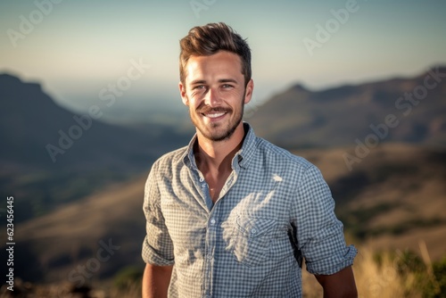 Eclectic portrait photography of a satisfied boy in his 30s wearing a casual short-sleeve shirt against a mountain range background. With generative AI technology