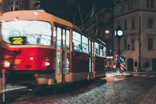 red tram in motion on city street at night