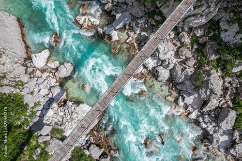 Suspension bridge in Soca valley over Soca river in Slovenia, top down drone view