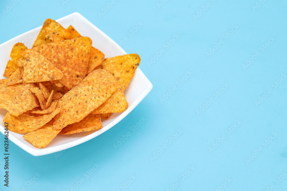 nachos on a plate on a blue background with copy space nachos on a plate on a blue background with copy space