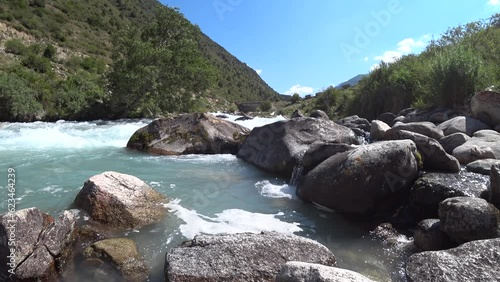 Small mountain river with crystal clear water. Water flows over the stones overgrown 4K photo