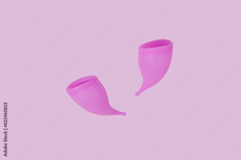 Pink reusable silicone menstrual cups on pink background. Concept of feminine hygiene, gynecology and health Pink reusable silicone menstrual cups on pink background. Concept of feminine hygiene, gynecology and health