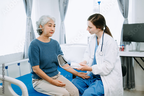 Woman Doctor and patient discussing something while sitting on examination bed in modern clinic or hospital . Medicine and health care concept.