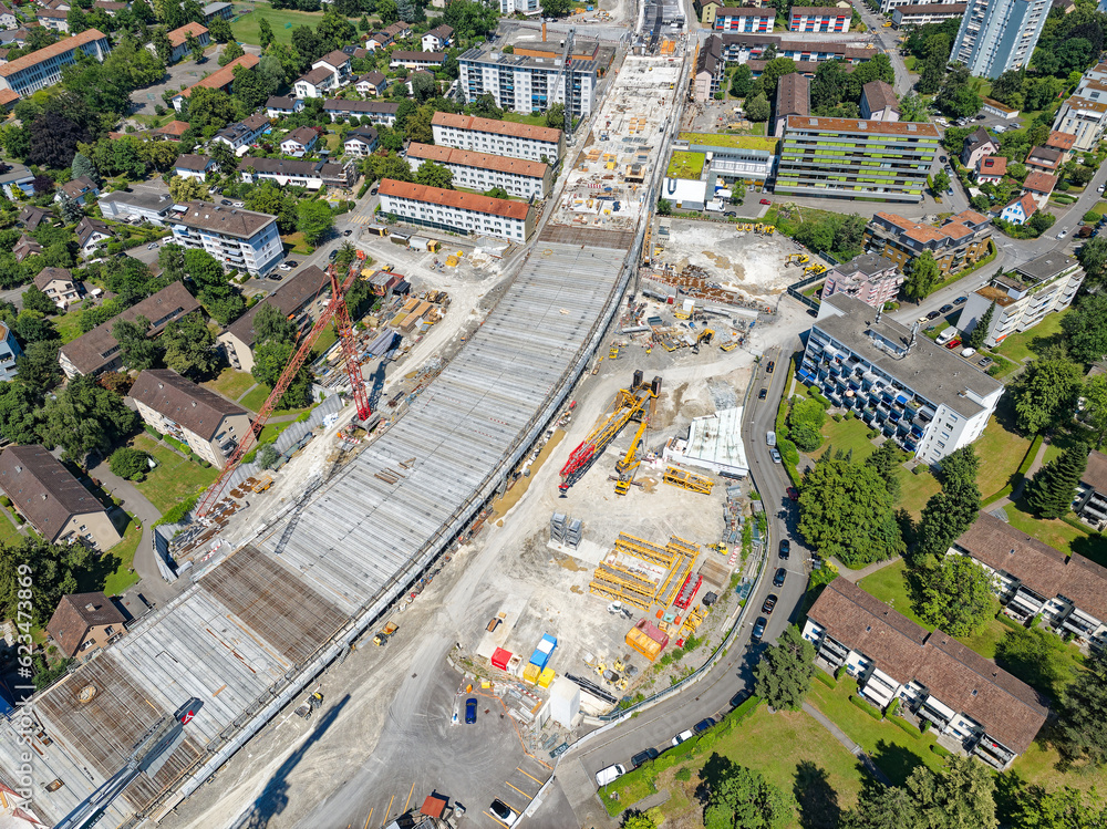 Naklejka premium Aerial view of City of Zürich district Schwamendingen with highway enclosure construction site on a sunny summer day. Photo taken June 24th, 2023, Zurich, Switzerland.