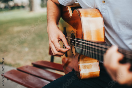 Fotobehang detail photograph of young man playing acoustic guitar outdoors