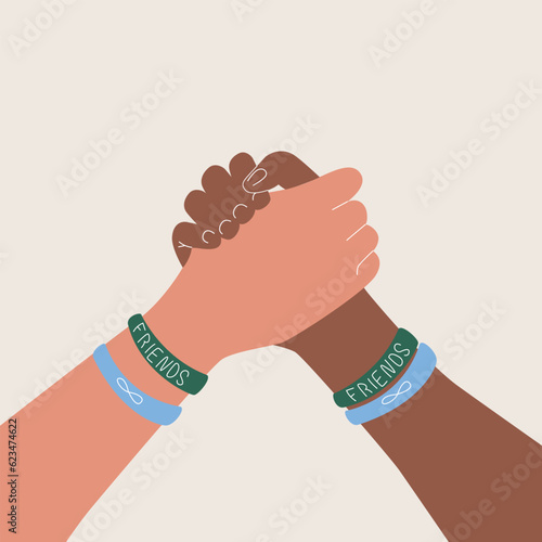 Friendship day banner with two person holding hands with colored bracelets on a white background with copy space