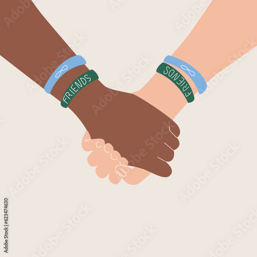 Friendship day banner with two person holding hands with colored bracelets on a white background with copy space