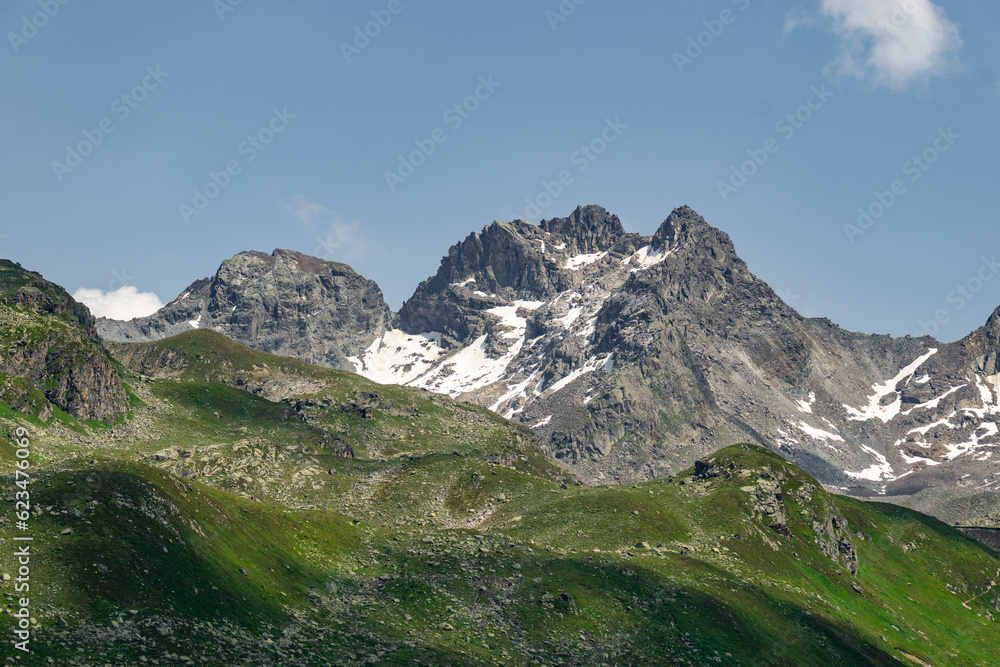 Steinige, steile Berge zwischen Tirol und Vorarlberg, Österreich, mit Schnee im Sommer und grünen Weiden aus dreistufiger Almwirtschaft. Wunderschönes Gebiet zum Klettern und Wandern, Erholung pur 
