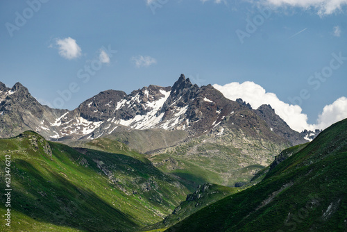 Steinige, steile Berge zwischen Tirol und Vorarlberg, Österreich, mit Schnee im Sommer und grünen Weiden aus dreistufiger Almwirtschaft. Wunderschönes Gebiet zum Klettern und Wandern, Erholung pur 