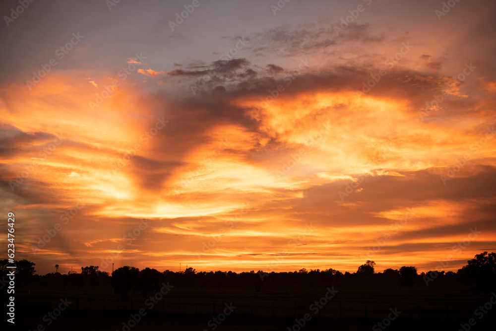 Glowing gold, orange-red, cloudy sky at sunset. Wallpaper concept. Glowing gold, orange-red, cloudy sky at sunset. Wallpaper concept.