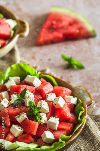 Fresh watermelon salad with feta cheese and mint on beige textured background